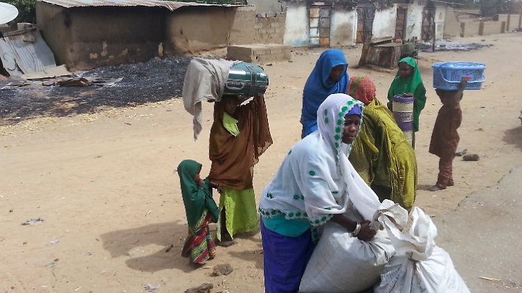 Frauen und Mädchen haben nach einem Überfall der Boko Haram auf ihr Dorf ihre Sachen gepackt.