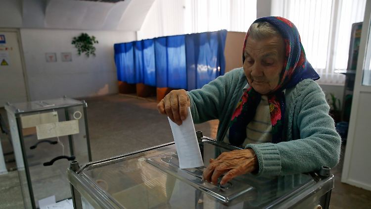 Eine Frau wirft in Slawjansk ihren Wahlzettel in die Urne.