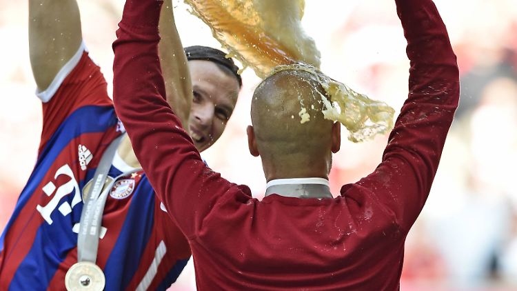 Das ist so lustig: Daniel van Buyten leert ein sehr großes Glas mit Bier über seinen Trainer.