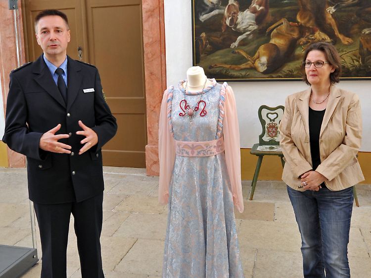 Und hier ist es: Polizeidirektor Hanjo Protze (l.) kann Schlossleiterin Ingrid Möbius (r.) das entwendete Kleid (M.) unbeschadet zurückgeben.