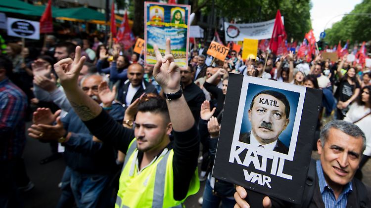 "Mörder" steht auf einem Protestplakat, das Erdogan als Hitler stilisiert. Die Veranstalter der Demo sprechen von 65.000 Teilnehmern.