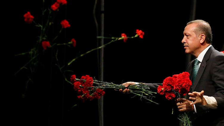 Erdogan wirft rote Blumen ins Publikum. Auch ohne Blumen hätte der türkische Premier seine Fans begeistert.