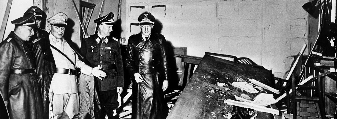 Hermann Göring (helle Uniform) und Hitlers Kanzleichef Martin Bormann (links) begutachten den zerstörten Raum der Kartenbaracke.