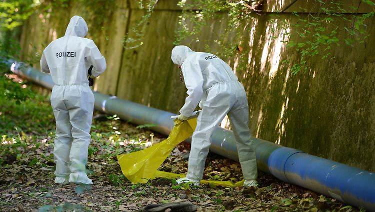 Mit Schutzanzügen sucht die Spurensicherung nach Hinweisen um Umkreis des Leichenfundortes.