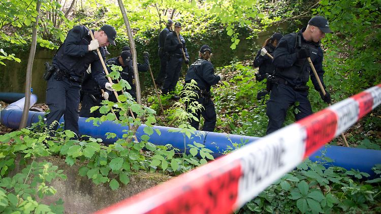 Ein Suchtrupp der Polizei sucht das Unterholz nach Spuren ab.