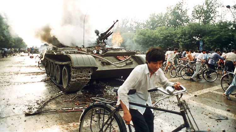 Menschen fliehen am 04. Juni 1989 vor einem in Brand gesetzten Panzer westlich des Tienanmen-Platzes.