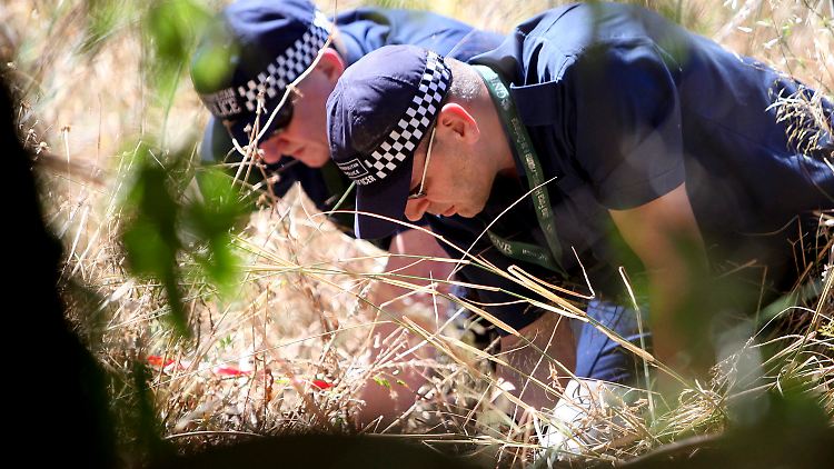 Hochkonzentriert bei der Sache: Zwei britische Polizisten suchen nach Hinweisen. 