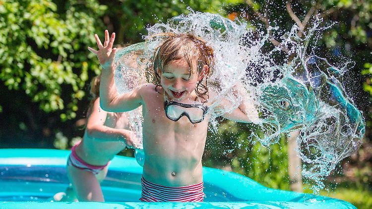 Geschwister spielen in einem Pool.