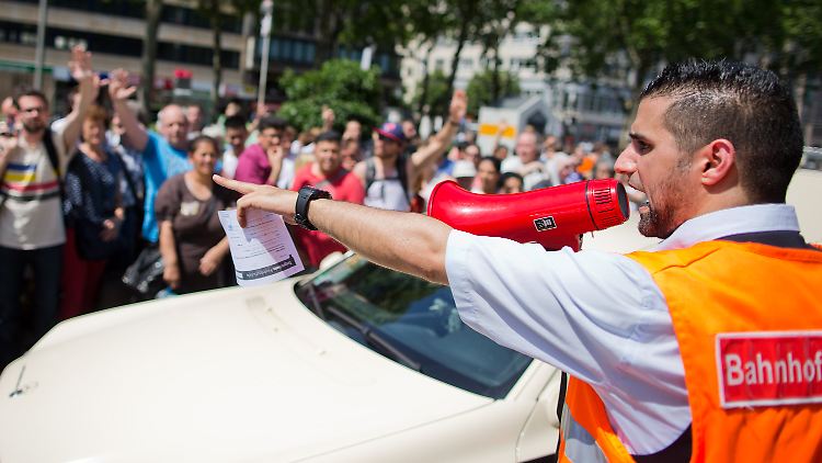 Chaos im NRW-Zugverkehr: Am Düsseldorfer Hauptbahnhof organisiert ein "Kundenservicemanager" per Megaphon die Weiterfahrt im Taxi.