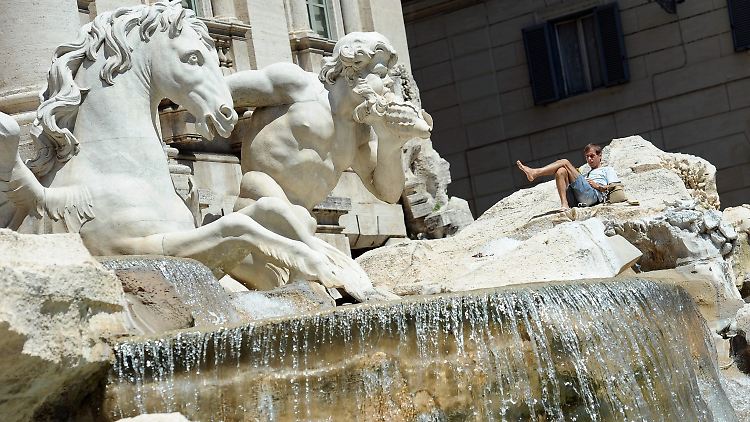 Spitzenplatz: Ein Tourist erfrischt sich auf dem Trevi-Brunnen.