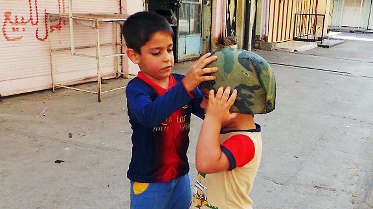 In Mossul spielen Kinder mit einem Armeehelm, den Soldaten nach der Flucht vor der Isis zurückgelassen haben.