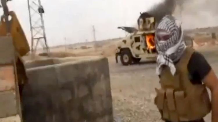 Dieser Screenshot aus einem Video zeig einen Isis-Kämpfer in Tikrit. Hinter ihm steht ein brennender Wagen der irakischen Armee.