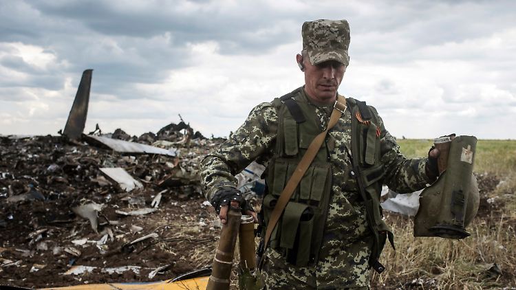Separatisten am Wrack der abgeschossenen ukrainischen Militärmaschine.