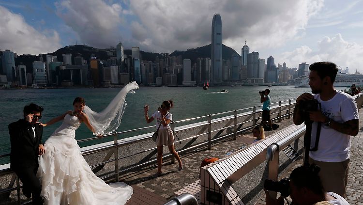 Alltagsszene in Hongkong: Ein Hochzeitspaar lässt sich vor dem Panorama des Geschäftsviertels fotografieren.