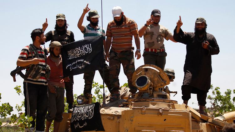 Mitglieder der Nusra-Front posieren auf einem erbeuteten Panzer.
