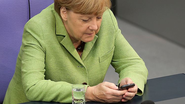 Merkel fingert an ihrem Handy während der Debatte um Finanzen, den Bundesrechnungshof und den Euro für Litauen.