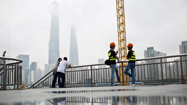 Später Juni in Shanghai: Unweit des Pudong-Viertels unterhalten sich Arbeiter und Angestellte über die aktuellen Börsengänge.
