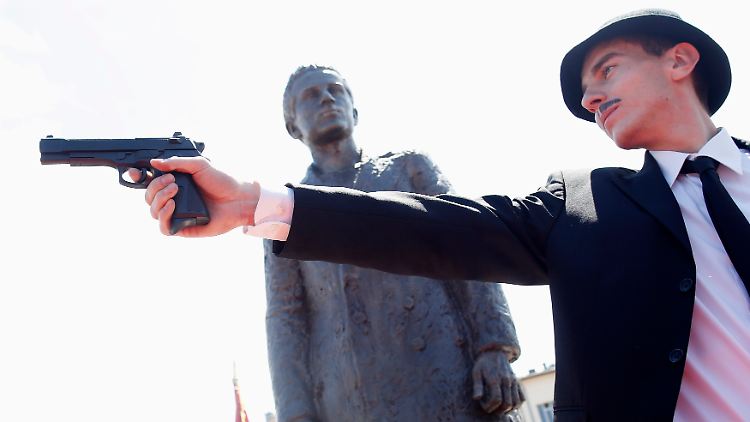 Der serbische Schauspieler Jovan Mojsilovic stellt vor dem Denkmal für Gavrilo Princip das Attentat von Sarajevo nach.