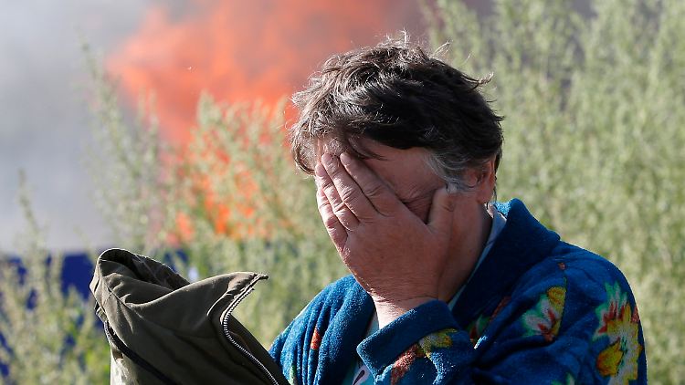 Eine Frau weint, als ihr Haus in Slavjansk nach einem Bombenbeschuss abbrennt.