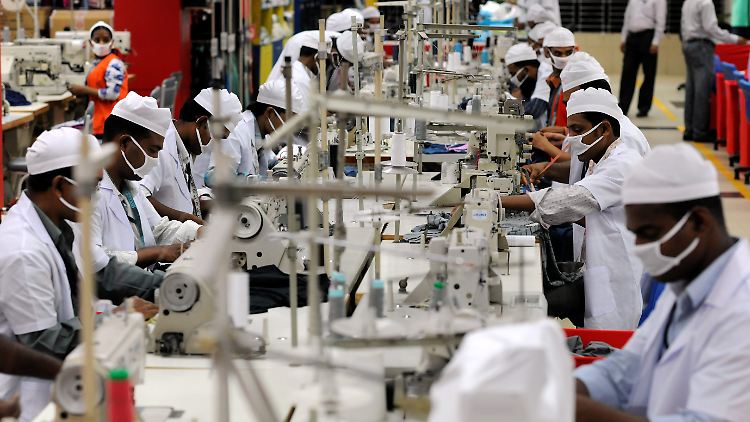 Mitarbeiter einer Textilfabrik in einem Vorort von Dhaka in Bangladesch nähen T-Shirts. Die Fabrik erfüllt die höchsten Standard. Sie produziert unter anderem auch für Marken wie Puma und Esprit. In anderen Betrieben der Textilindustrie Asiens sind die Arbeitsbedingungen nicht so mustergültig.
