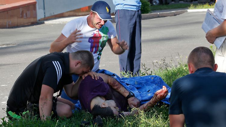 Zwei Männer betrauern völlig fassungslos den Tod ihres Freundes. Der Polizist war nur Minuten zuvor beim Sturm prorussischer Rebellen auf eine Regierungseinrichtung von Donezk tödlich verwundet worden.