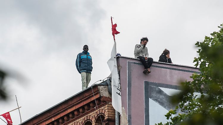 Immer wieder zeigen sich auf dem Dach der Schule die Flüchtlinge mit ihren deutschen Unterstützern.