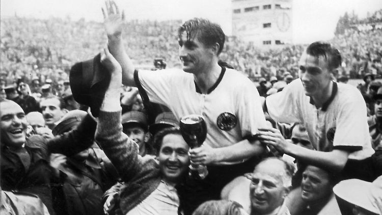 Der deutsche Kapitän Fritz Walter und sein Lauterer Teamgefährte Horst Eckel (r) werden nach dem Triumph im Berner Wankdorfstadion von begeisterten Anhängern vom Spielfeld getragen.
