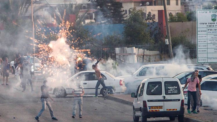 Protestierende Palästinenser werfen in Ar'Ara Feuerwerkskörper auf israelische Polizisten.