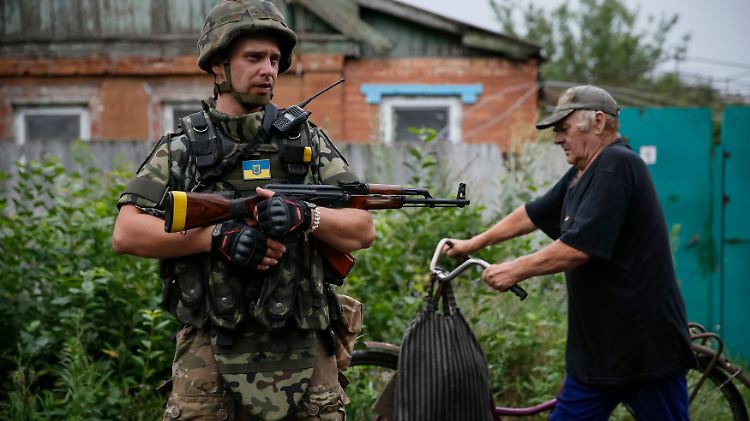 Alltag in der Ukraine: Ein ukrainischer Soldat einer Spezialeinheit und ein Passant in dem Dorf Semenowka.