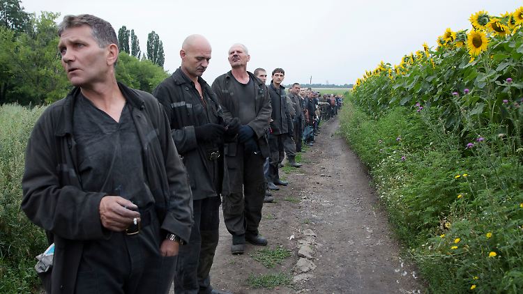 Das Absturzgebiet ist so groß wie Norderney. Kohlearbeiter sammeln sich an einem Feld, um Trümmer und Leichen zu suchen.