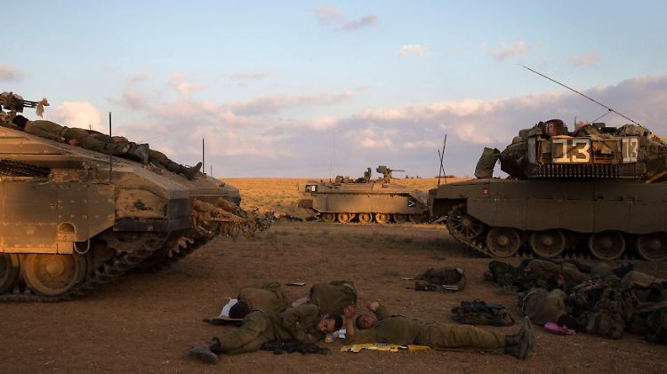 Israelische Soldaten ruhen an ihren Panzern aus.