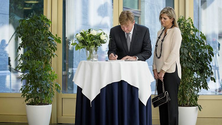 Der niederländische König trägt sich in ein Kondolenzbuch ein.