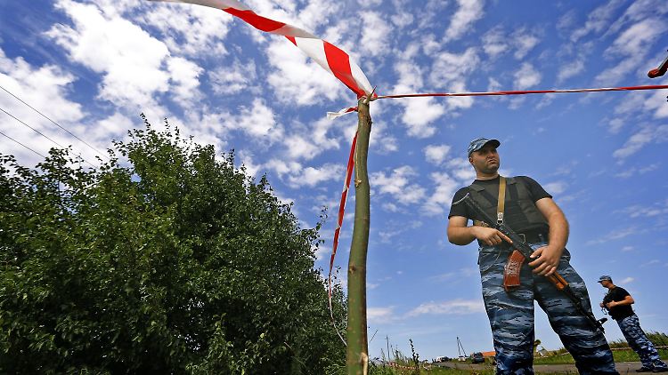 Separatisten stehen an der Absturzstelle von Flug MH17.