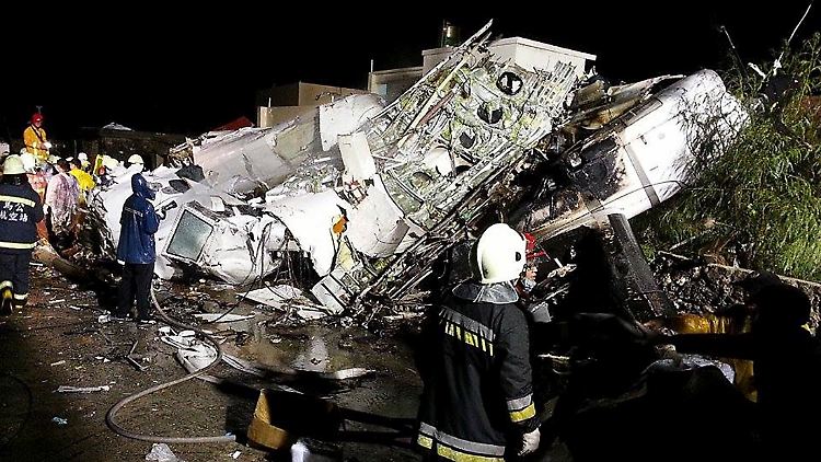 Rettungskräfte durchsuchen die völlig zerstörten Überreste der Maschine nach Überlebenden.