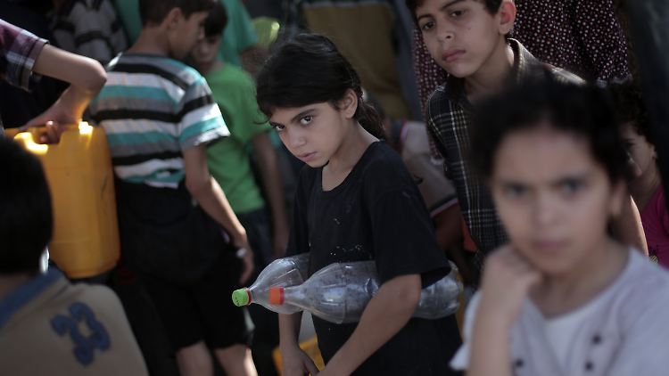 Im nördlichen Gazastreifen warten Kinder darauf, ihre Behälter mit Wasser füllen zu können.