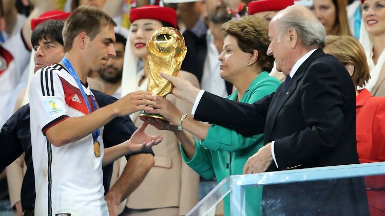 Hier übergibt Fifa-Boss Sepp Blatter den WM-Pokal an Philipp Lahm. Die Einnahmen der Fußball-WM behält der Fußball-Weltverband allerdings weitgehend für sich.