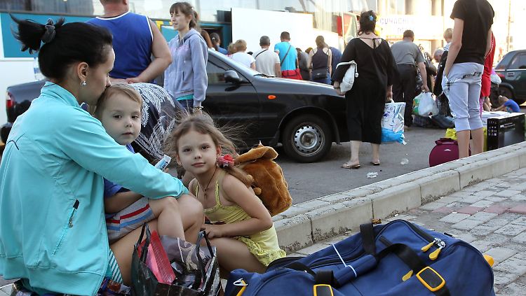 Eine junge Mutter wartet mit ihren Töchtern auf die Abfahrt aus Horliwka. Die Stadt wird von Separatisten gehalten, jetzt drohen neue Kämpfe mit der ukrainischen Armee.