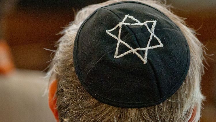 Ein Mann mit einer Kippa sitzt in der Synagoge in Dresden.