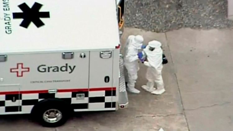Sanitäter in Schutzanzügen tragen den infizierten Arzt auf eine isolierte Seuchenstation in einem Krankenhaus in Atlanta.