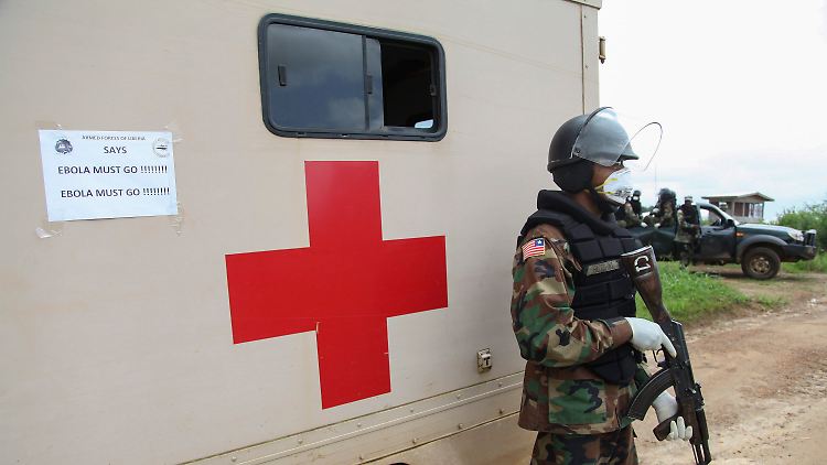 Ein liberianischer Militärpolizist schützt die Beerdigung von Ebola-Opfern nahe Monrovia.