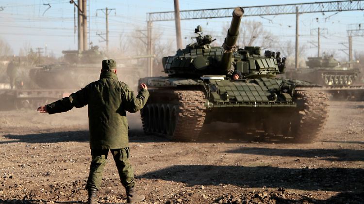 Ein Soldat weist einen russischen T-72-Panzer nach dem Transport per Zug den Weg zu seinem neuen Bestimmungsort.