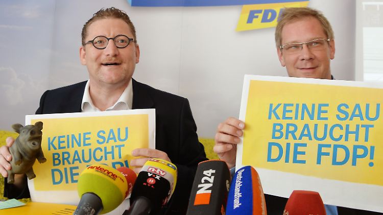 Oink, Oink - Der brandenburger FDP-Vorsitzende Gregor Beyer (l.) quitscht mit dem Gummischwein. Spitzenkandidat Andreas Büttner belässt es beim Plakat.