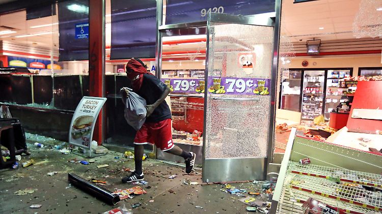 Ein Plünderer flieht aus einem Laden in Ferguson.