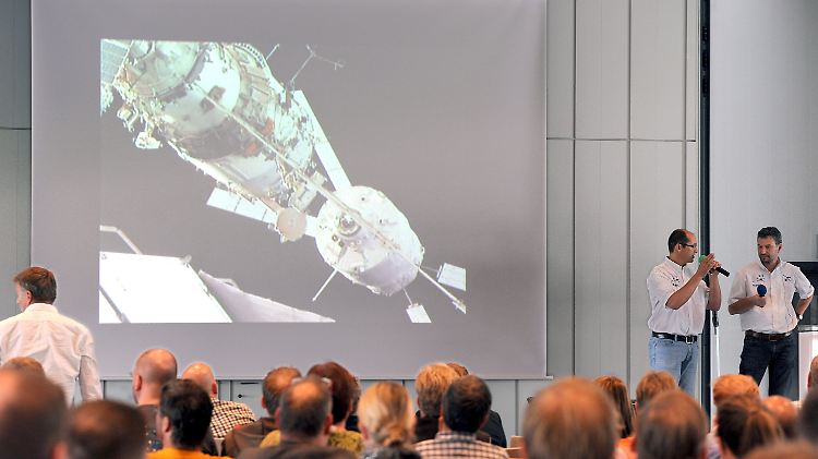 Die Mitarbeiter von Airbus Defence & Space, der für das ATV-Cargo zuständige Rachid Amekrane (l) und der stellvertretende ATV-Programmleiter Michael Teichwart kommentieren in Bremen den Dockingvorgang von "Georges Lemaitre" an die ISS.