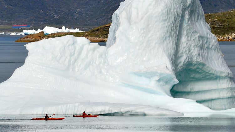 Kajakfahrer vor einem Eisberg im Ford von Narsaq, Grönland.