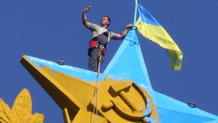 Die gelb-blaue ukrainische Staatsflagge hängt auf einem Hochhaus in Moskau. Zudem bemalten die Aktivisten den goldenen Sowjetstern zur Hälfte blau an.
