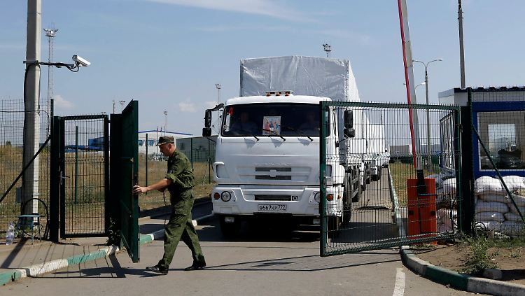 Russische Grenzer öffnen die Tore für die weißen LKW.