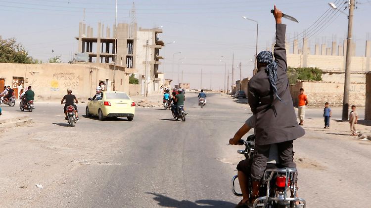 Ein Mann jubelt mit einem Messer in Al-Tabka über den Sieg der IS.