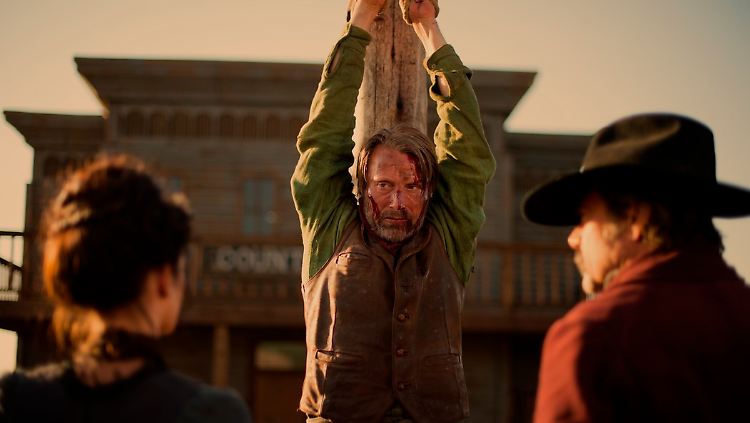 Noch hängt Mads Mikkelsen am Pfahl - doch bald nimmt er den Kampf gegen Gangsterboss Jeffrey Dean Morgan (r.) und Eva Green (l.) auf.