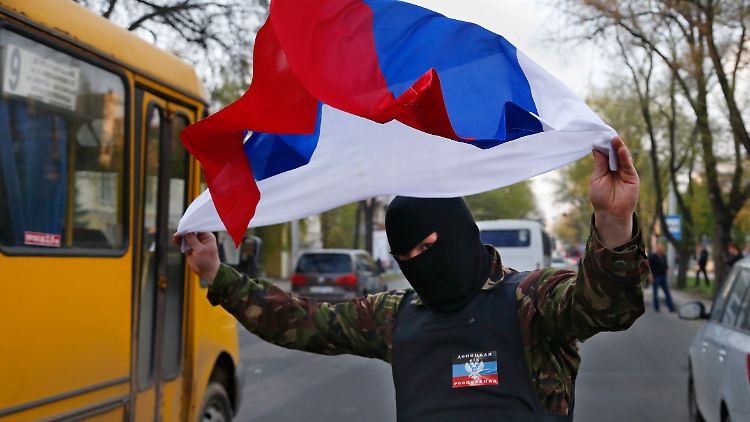 Ein Unterstützer der Rebellen schwenkt im ukrainischen Donezk die russische Fahne. 